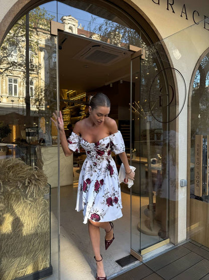 Woman in a floral dress walking out of a store with 'Grace' branding.