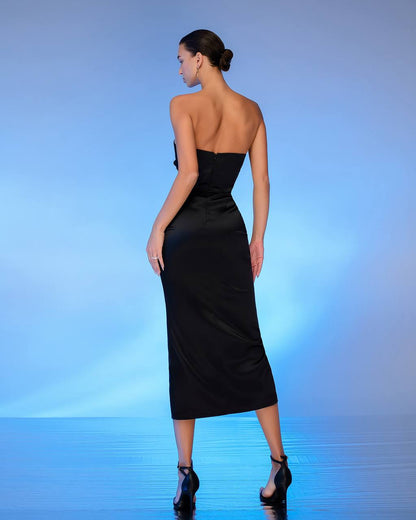 Woman wearing a black strapless dress on a blue gradient background