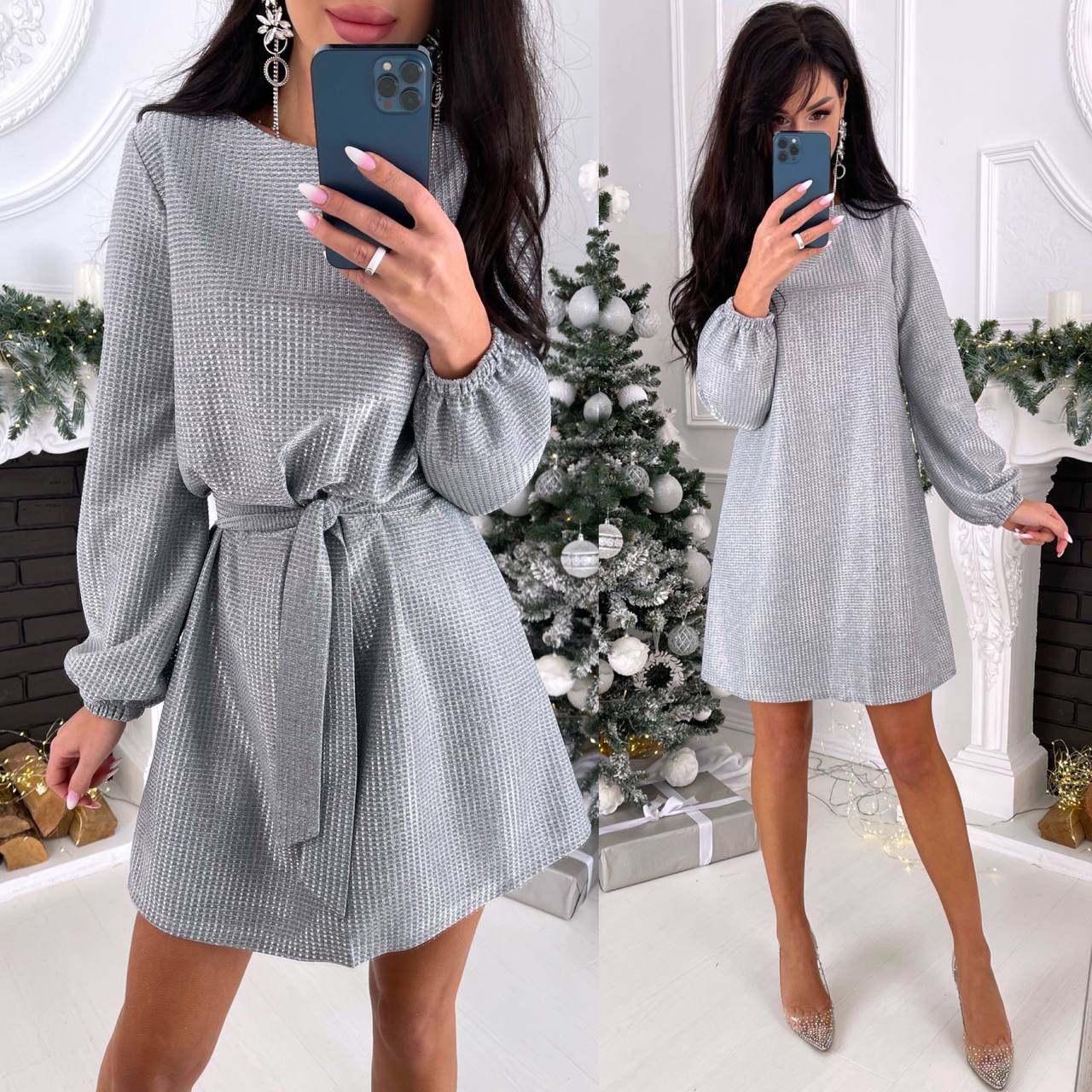 Woman wearing a gray checkered dress in a festive indoor setting with a Christmas tree.