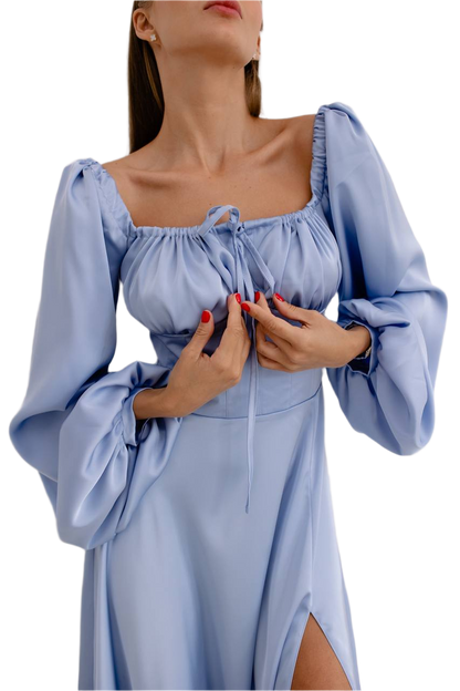 Woman wearing a light blue dress with long sleeves on a white background