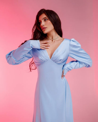 Woman wearing a light blue dress against a pink background