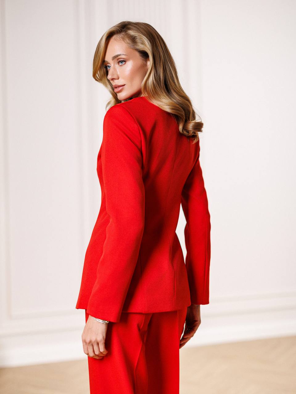 Woman wearing a red suit against a white background