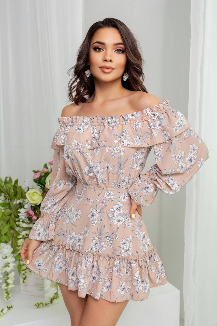 Woman wearing a floral off-shoulder dress with a white curtain and flowers in the background