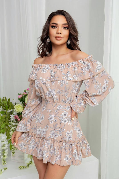 Woman wearing a floral off-shoulder dress with a white curtain and flowers in the background