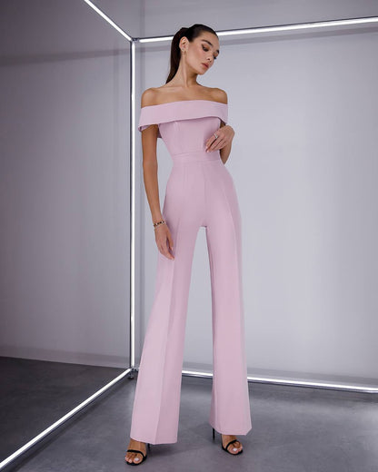Woman wearing a pink off-shoulder jumpsuit in a minimalistic setting
