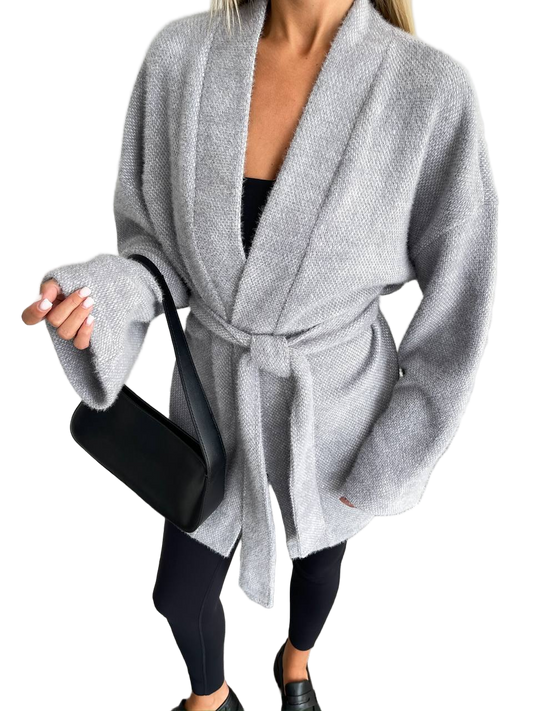 Person wearing a gray robe over black leggings on a white background