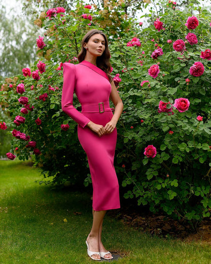 Woman in a bright pink dress standing in front of pink flowers