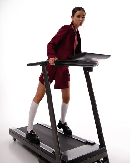 Woman in a red outfit using a treadmill on a white background