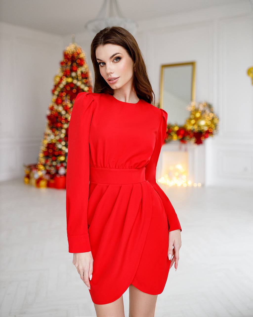 Woman wearing a red dress in a festive room with Christmas decorations.