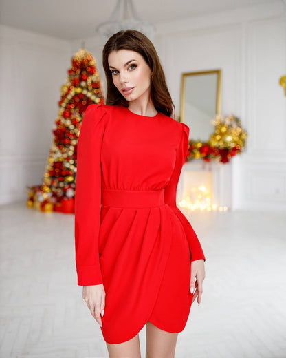 Woman wearing a red dress in a festive room with Christmas decorations.