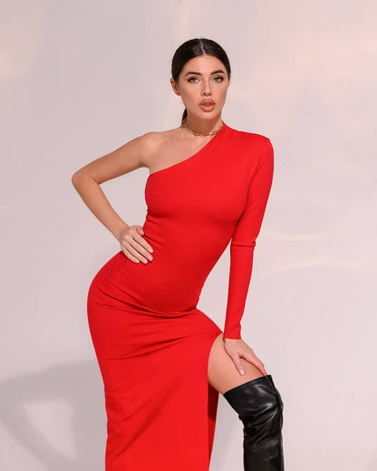 Woman wearing a red one-shoulder dress with a slit, standing against a plain background.