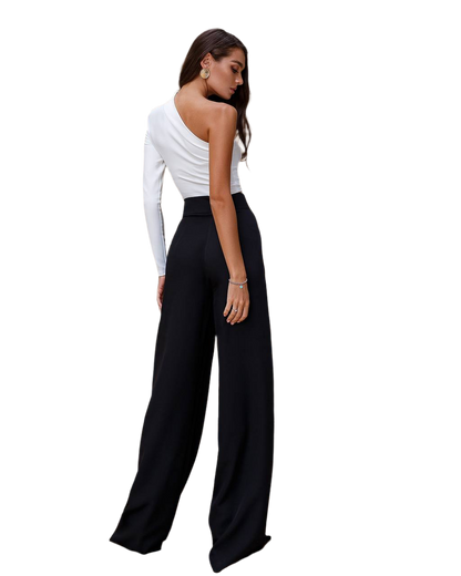 Woman wearing a white one-shoulder top and black wide-leg pants on a white background