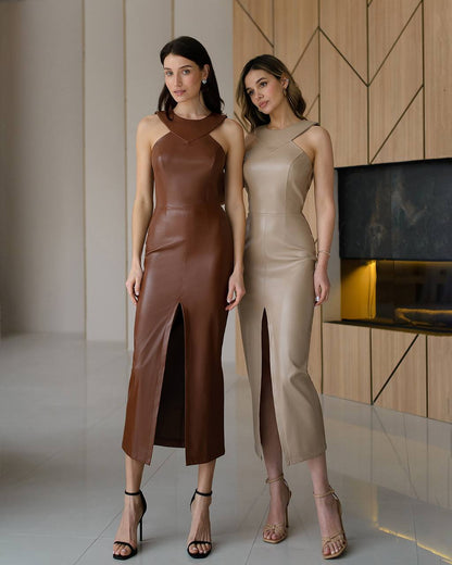 Two women wearing leather dresses standing in a modern interior setting.