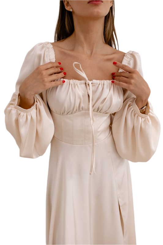 Beige dress with long sleeves and a fitted waist on a white background