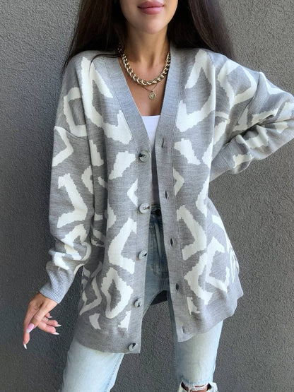 Person wearing a gray patterned cardigan against a plain background