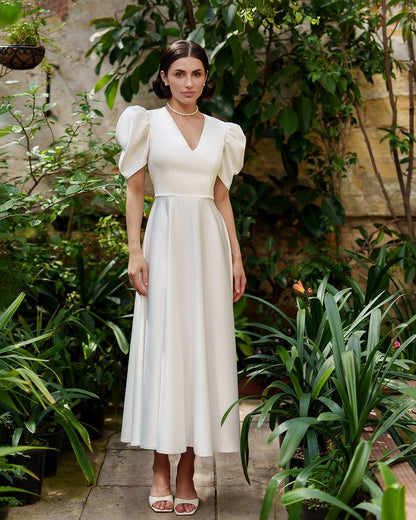 Woman in a white dress standing in a garden setting
