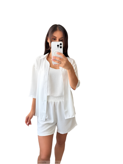 Woman taking a selfie in a white outfit on a white background
