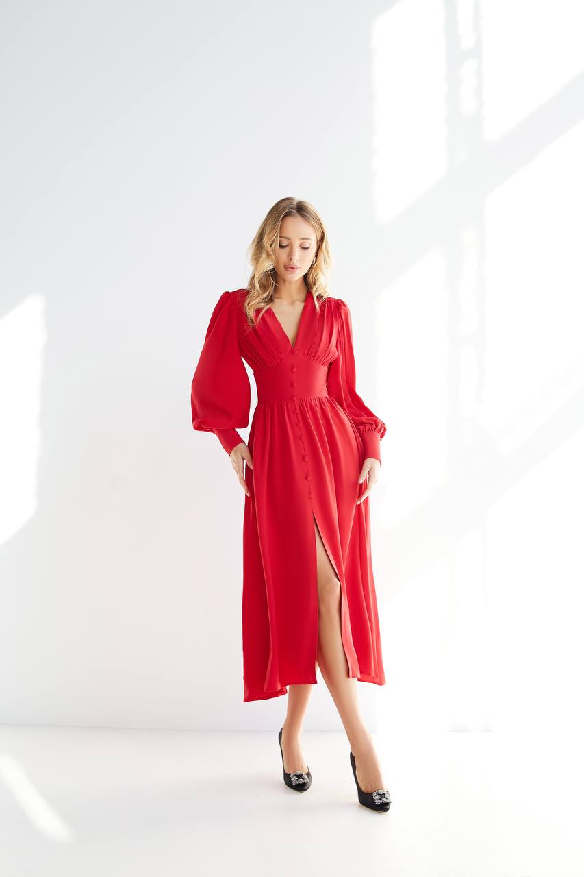 Woman wearing a red dress with a slit on a white background