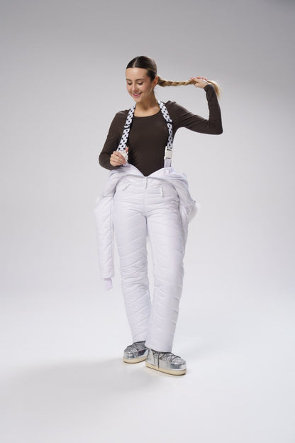 Person wearing white overalls with suspenders on a gray background