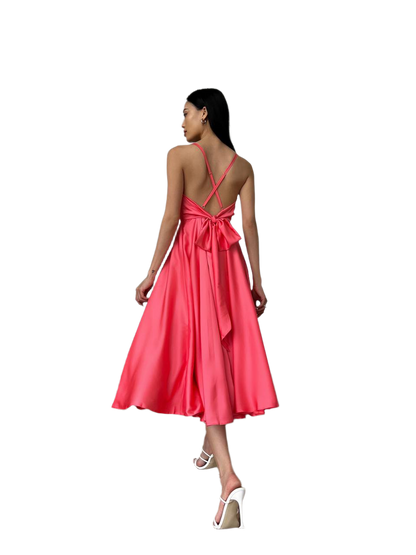 Woman wearing a pink dress with a bow detail on a white background