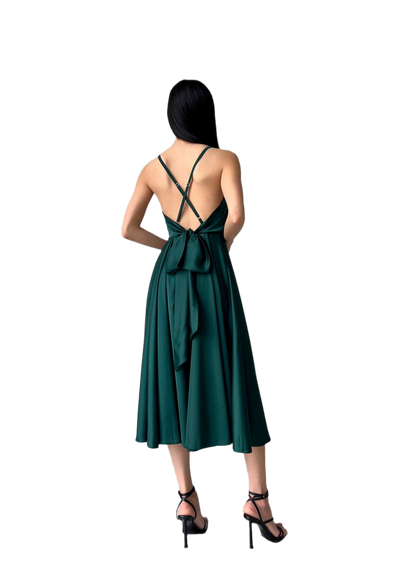 Woman wearing a green dress with a bow detail on a white background