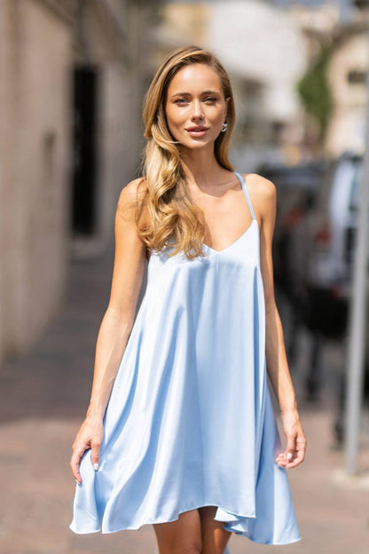 Woman wearing a light blue dress on a city street