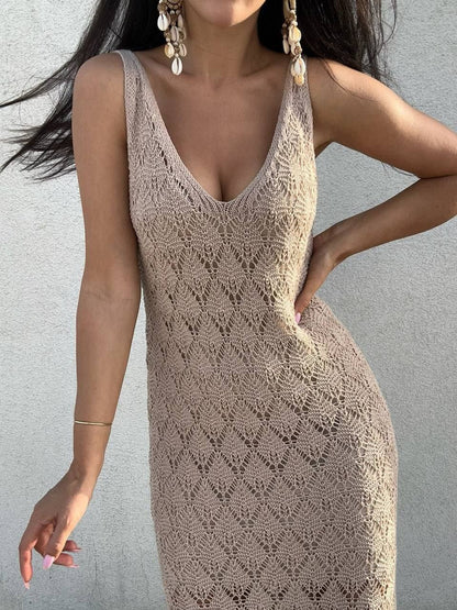 Woman wearing a beige crochet dress against a plain background