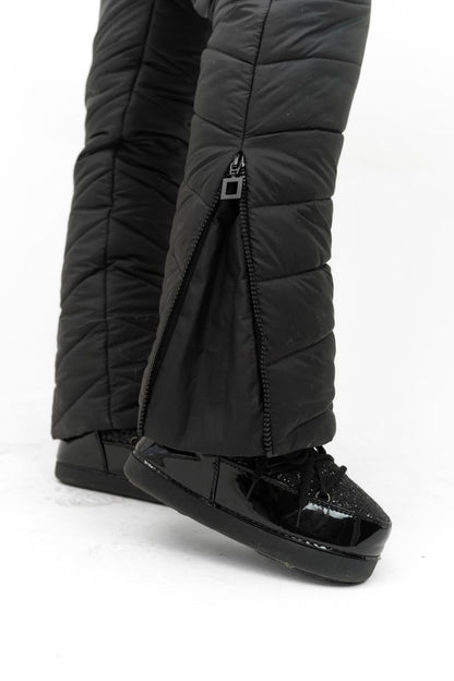 Black puffer pants with attached black shoes on a white background