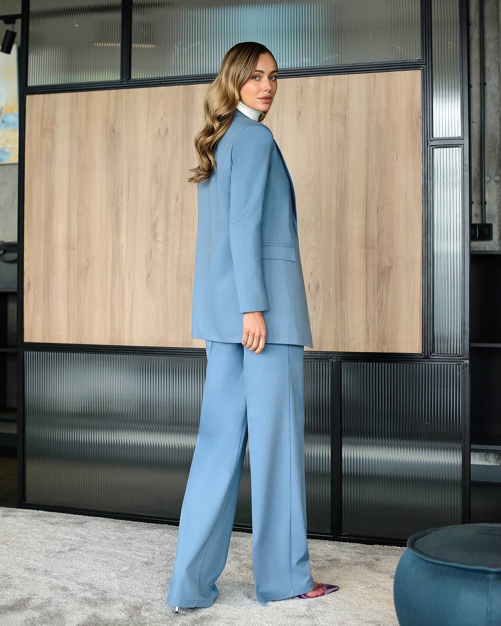 Woman in a blue suit standing in an office setting