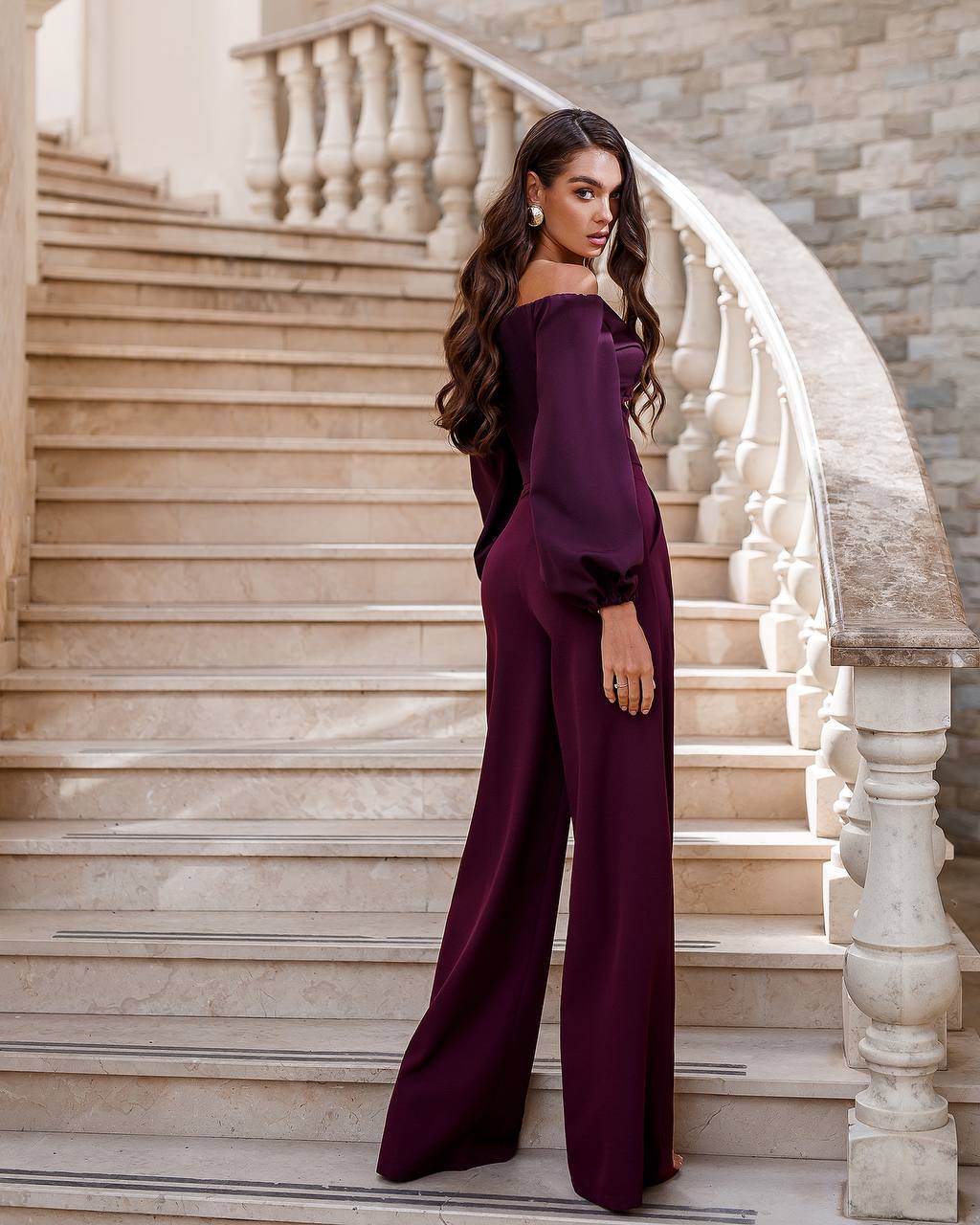 Woman in a purple outfit standing on a staircase