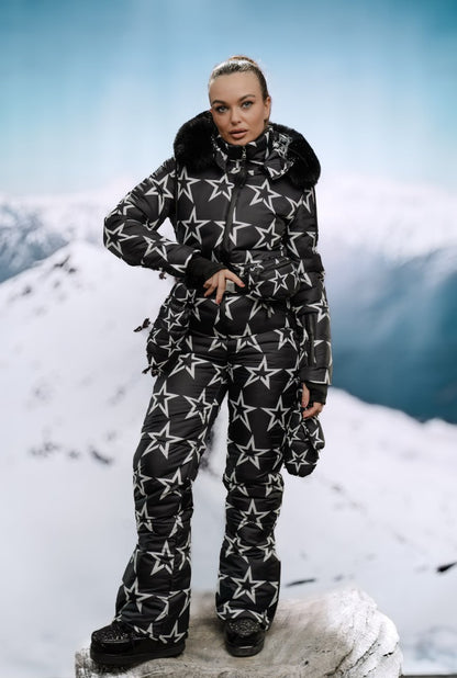 Person wearing a black and white star-patterned snowsuit on a snowy mountain background