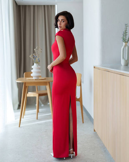 Woman in a red dress standing in a modern room with neutral decor.