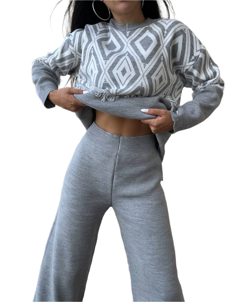 Person wearing a gray and white patterned sweater and matching pants on a white background