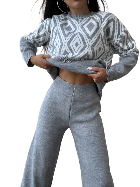 Person wearing a gray and white patterned sweater and matching pants on a white background