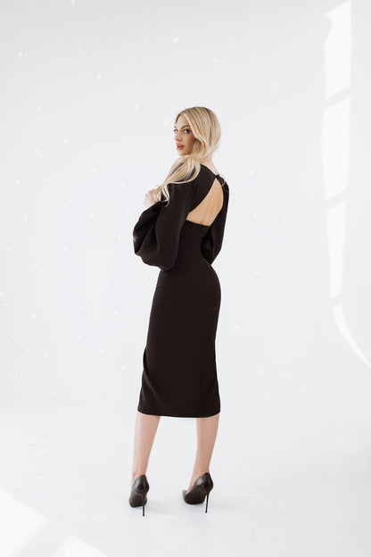 Woman wearing a black dress with cut-out shoulders on a white background