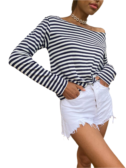 Woman wearing a black and white striped long-sleeve top with a white background