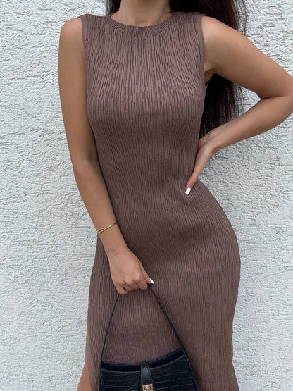 Woman wearing a brown ribbed dress against a light gray wall