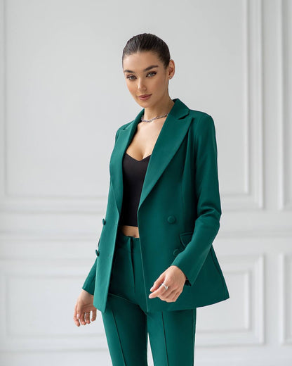 Woman wearing a green suit against a white wall