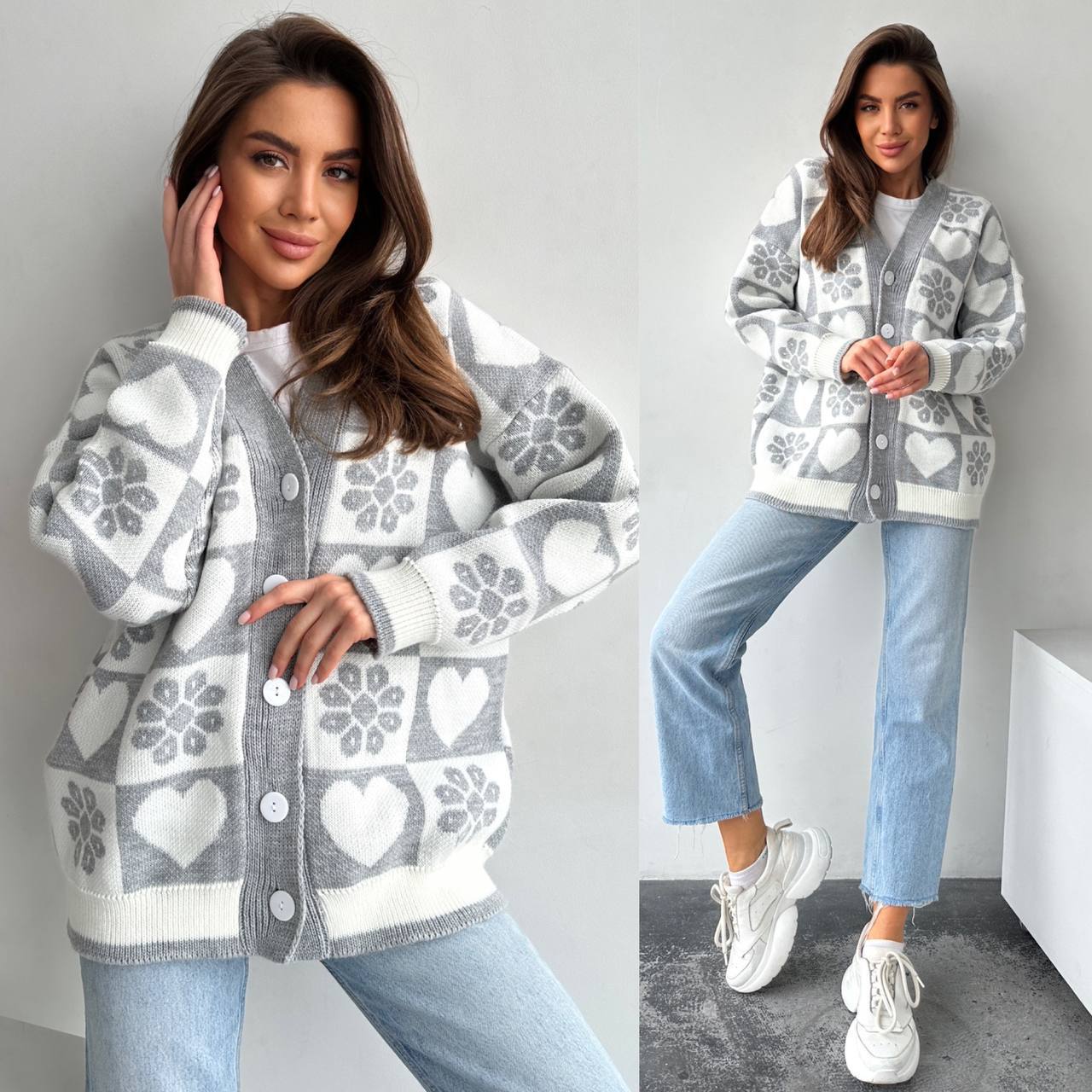 Woman wearing a patterned cardigan with hearts, light blue jeans, and white sneakers on a plain background.