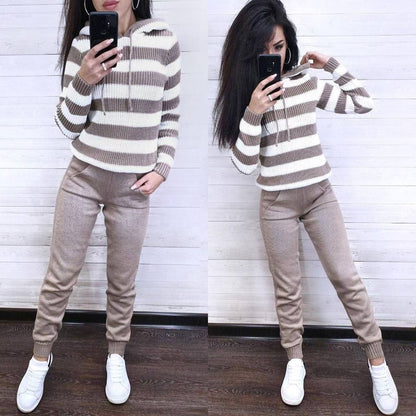 Woman wearing a striped sweater and beige pants, standing in front of a mirror.