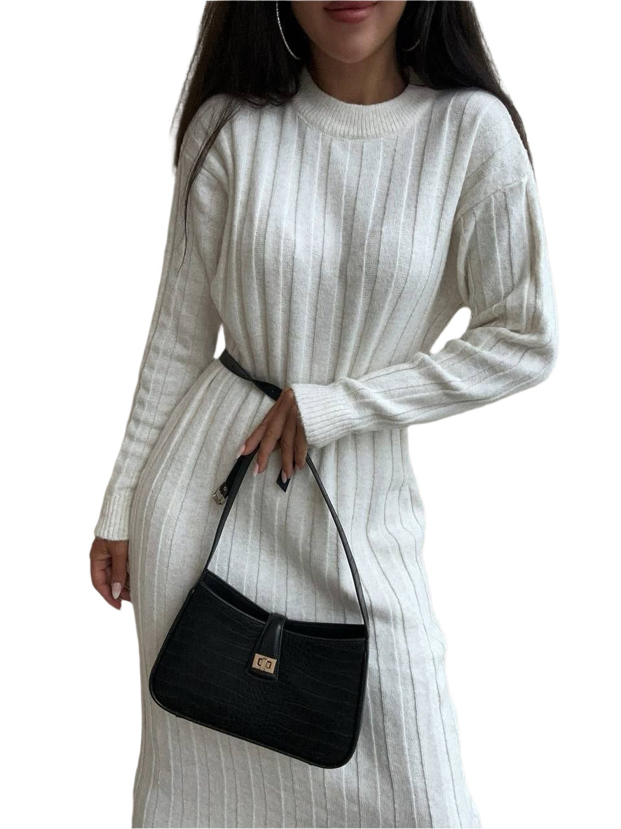 Woman wearing a white ribbed sweater dress holding a black handbag on a white background