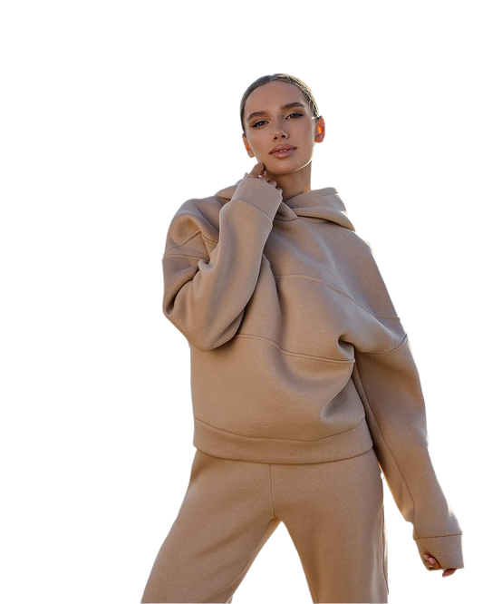 Person wearing a beige hoodie and pants on a white background
