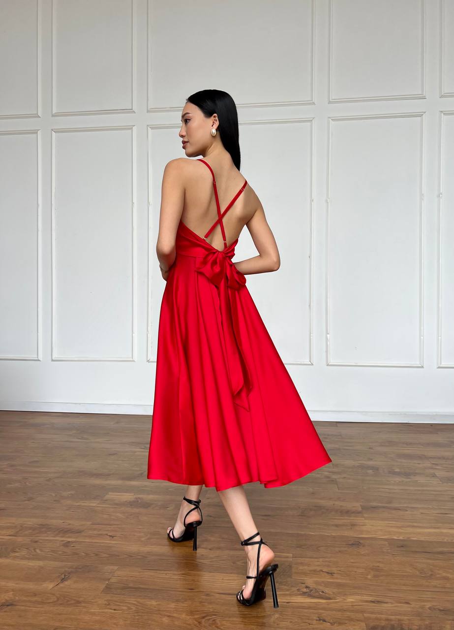 Woman wearing a red dress with a white paneled wall background