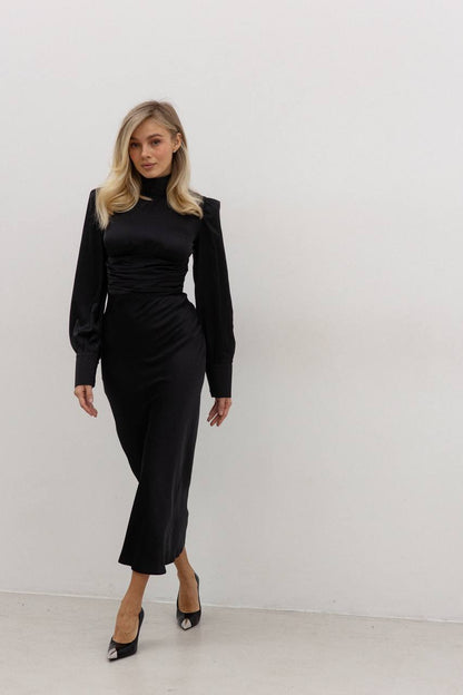 Woman wearing a black dress against a white background