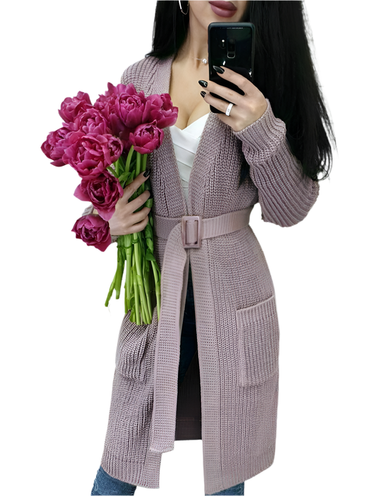 Person wearing a long knitted cardigan holding pink flowers on a white background