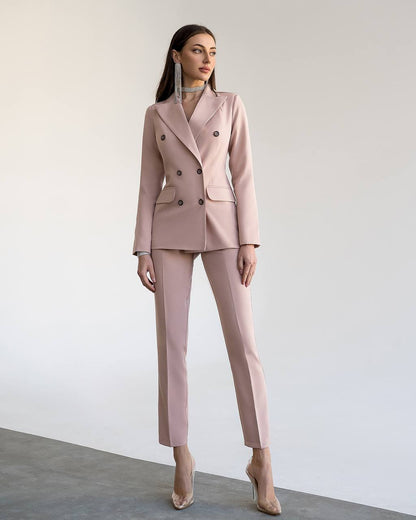 Woman wearing a pink suit against a plain background
