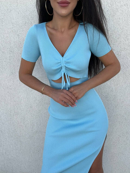 Woman wearing a light blue dress with a cutout design against a plain background