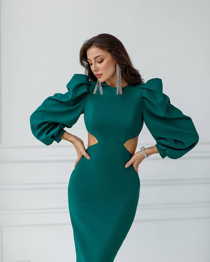 Woman wearing a green dress with puffed sleeves against a white background