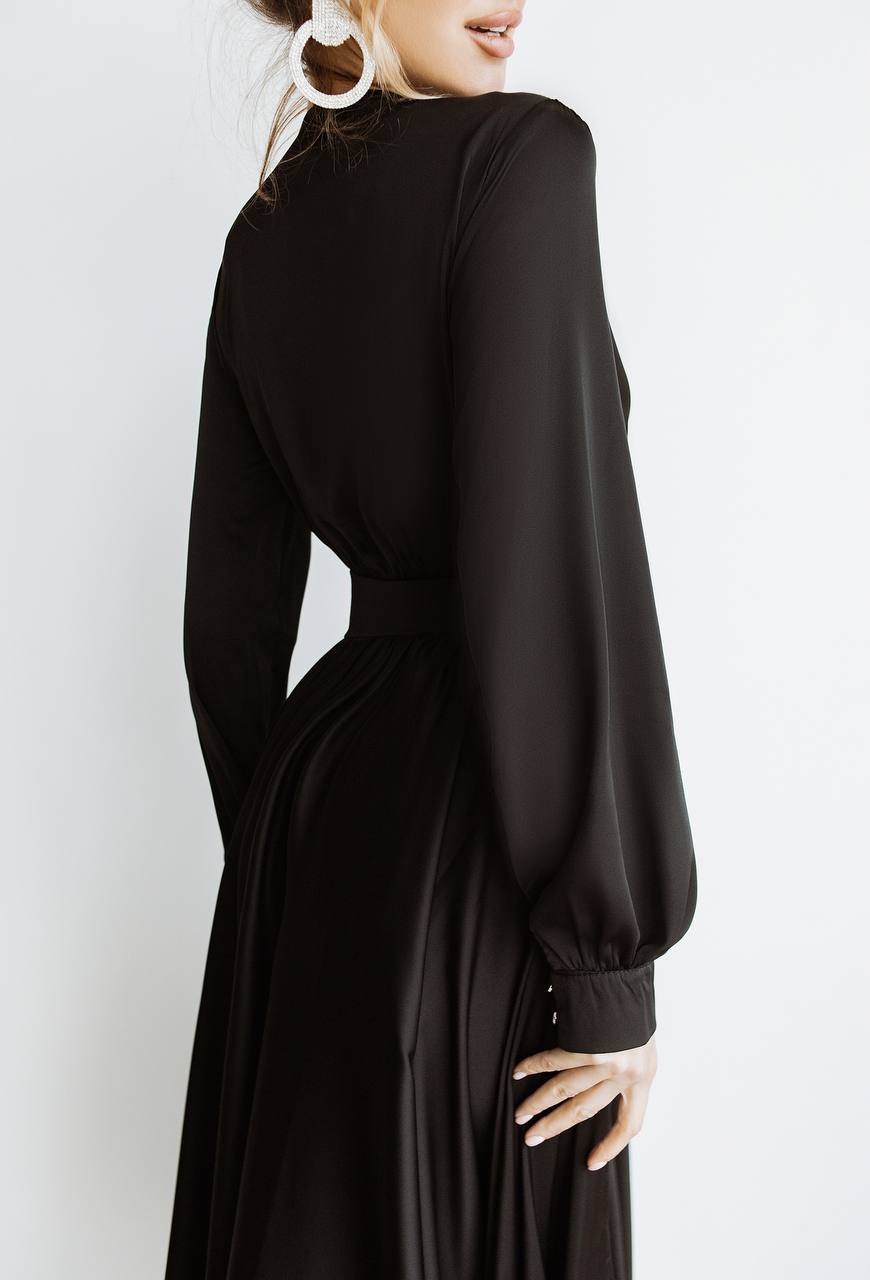Black long-sleeve dress worn by a person on a white background