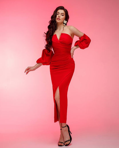 Woman wearing a red dress with puffed sleeves on a pink background